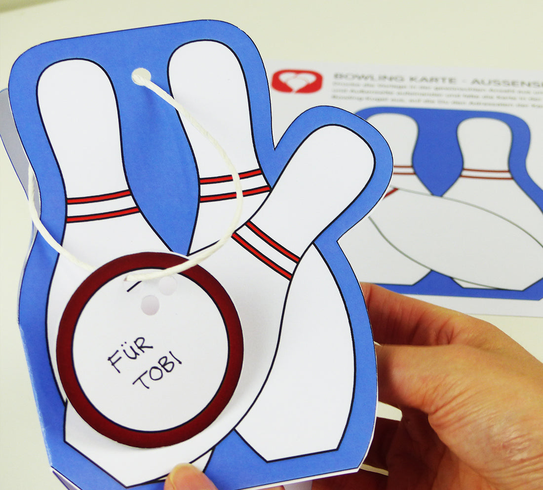 Auf der Rückseite der angebrachten Bowling Kugel an der Einladungskarte kann der Empfänger eingetragen werden, zum Beispiel "für Tobi".