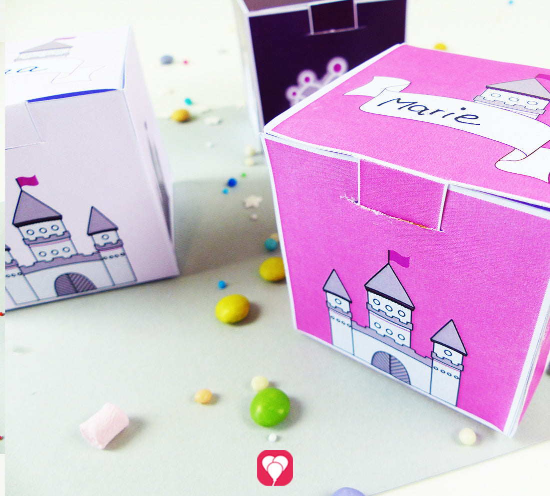 Fertiggebastelte Geschenkboxen in den drei unterschiedlichen Farben aus dem Bastel-Set "Märchenschloss Geschenkbox" von balloonas. Eine der Geschenkboxen ist mit dem Namen Marie beschriftet.