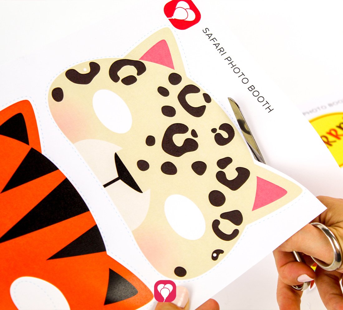 Das Leoparden-Motiv aus dem Bastelvorlagen Set "Safari Photo Booth" wird mit einer Schere entlang der Linie ausgeschnitten.