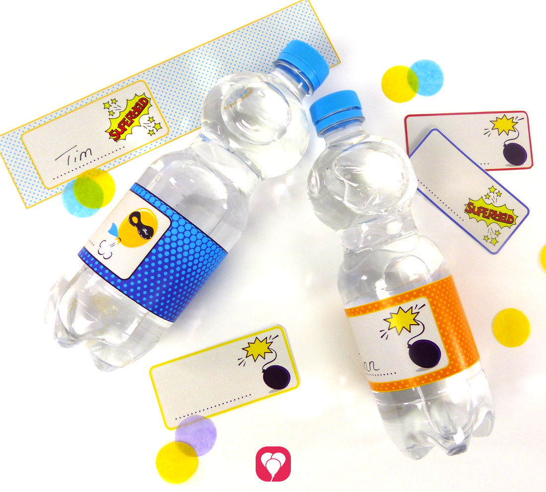 Zwei Wasserflaschen, versehen mit den Do-it-yourself Flaschenetiketten von der Bastelvorlage "Superhelden" von balloonas. Im Hintergrund liegen weitere unbeschriftete Tischkarten und Flaschenetiketten aus dem Motto-Paket.