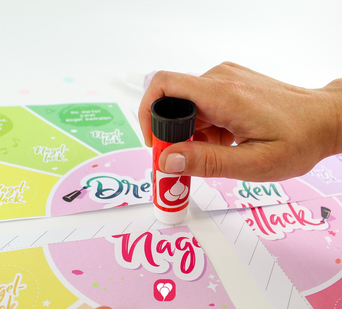 Im nächsten Schritt werden alle vier Ausdrucke für das balloonas Beauty Party Spiel mit einem Klebestift zusammengeklebt.